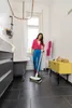 A woman is using a steam mop in a bathroom. Anteprima dell’immagine prodotto
