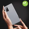 Hands holding a Samsung Galaxy Note 20 phone with a gray fabric case. Produktbild-Vorschau