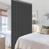 A bedroom with two beds, separated by a dark gray room divider curtain. One bed is in the foreground, and the other is in the background. Náhled obrázku produktu