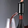 A person's finger is pressing the top of an electric wine dispenser attached to a wine bottle, while red wine is being poured into a wine glass. Anteprima dell’immagine prodotto