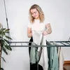 A woman is hanging laundry on a ceiling-mounted drying rack. Produktbild-Vorschau