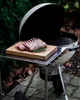 A rack of lamb seasoned and placed on a wooden cutting board next to a grill. Náhled obrázku produktu
