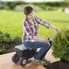 A woman is gardening while sitting on a wheeled garden cart. Produktbild-Vorschau