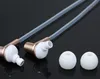 A close-up studio shot of two in-ear headphones and two ear tips against a black reflective background. Produktbild-Vorschau