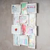 A collage of 12 framed photos, arranged on a textured gray wall. Produktbild-Vorschau