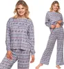 A woman is shown wearing a grey pajama set with a Nordic-inspired pattern featuring reindeer and geometric shapes. The image is presented as a collage with two views of the same model. Produktbild-Vorschau