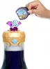 A hand is holding a small, clear container with a purple lid, which appears to be a potion or a magical ingredient, over the top of a bottle filled with purple liquid. The bottle has a decorative gold and purple cap with a blue gem. Podgląd zdjęcia produktu