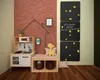 A children's play area with a toy kitchen, a bench with storage, and a climbing wall with chalkboards. Anteprima dell’immagine prodotto