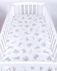 A white crib with a fitted sheet featuring a pattern of beige teddy bears and clouds. Produktbild-Vorschau