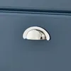 A close-up of a silver drawer pull on a blue cabinet. Voir les images du produit