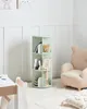 A child's room with a rotating bookshelf, a plush armchair, and a small table. Náhled obrázku produktu