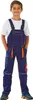 A young boy is standing and posing for a product photo, wearing blue overalls with orange accents. Produktbild-Vorschau