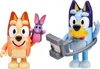Two Bluey character figures are shown against a white background. The figure on the left is orange and is holding a purple and pink bunny puppet. The figure on the right is blue and is holding a gray camera-like accessory. Voir les images du produit