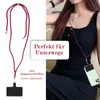 A person wearing a black tank top and black pants, with a red lanyard around their neck holding a phone case. The image is split into two halves, with the left side showing a close-up of the lanyard and phone case, and the right side showing the person wea Produktbild-Vorschau