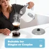 A woman is pouring hot water from a kettle into a coffee maker. Produktbild-Vorschau