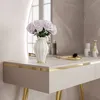 A close-up of a vanity table with a vase of flowers and some cosmetic items. Náhľad obrázku produktu