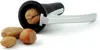 A nutcracker with a walnut inside, and other nuts in front of it, on a white background. Podgląd zdjęcia produktu