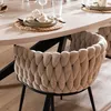 A close-up of a dining chair with a braided backrest, placed at a dining table. Produktbild-Vorschau