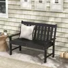 A black garden bench with a white pillow sits on a patio next to a small side table with a plant. Produktbild-Vorschau
