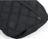 A close-up view of a black quilted footmuff with a zipper. Produktbild-Vorschau