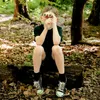 A young boy sits on a log in a forest, looking through binoculars. Náhľad obrázku produktu