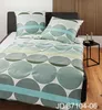 A bed with bedding set on it, with a headboard and a small side table with candles. Produktbild-Vorschau