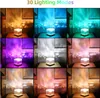 A collage of nine images showing a cube-shaped lamp projecting colorful light patterns onto a wall. Produktbild-Vorschau