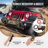 A red Jeep Wrangler is stuck in sand, with a winch attached to its front bumper. The image also shows close-ups of a wired and a wireless remote control for the winch. Náhled obrázku produktu