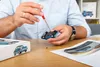 A person is assembling a model car with a screwdriver, with the product box and instructions nearby. Náhľad obrázku produktu