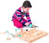 A young boy is playing with a wooden toy tool set. Podgląd zdjęcia produktu