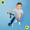 A young boy is smiling next to a black three-wheeled scooter with blue LED lights. Anteprima dell’immagine prodotto