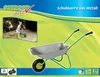 A child is shown using a metal wheelbarrow in a barn setting, with the product itself prominently displayed. Produktbild-Vorschau