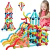 A young girl plays with colorful magnetic building blocks, constructing various shapes and structures. Voir les images du produit