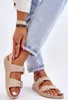 A close-up shot of a person's legs wearing beige sandals and light blue jeans. Produktbild-Vorschau