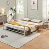 A bedroom scene with a white metal bed frame, bedding, and a rug. Produktbild-Vorschau