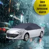A silver car covered with a dark gray car cover, parked on a wet street at night with rain falling. Anteprima dell’immagine prodotto