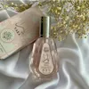 A bottle of Ard Al Zaafaran Yara perfume and its box are displayed on a white, draped fabric background, with dried flowers in the upper right corner. Produktbild-Vorschau