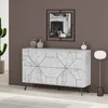 A modern living room scene featuring a white marble-patterned sideboard with geometric black lines, a decorative mirror, vases, and a floor lamp. Náhled obrázku produktu