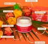 A jar of face cream is surrounded by orange flowers and green leaves, with arrows pointing to different benefits of the cream. Produktbild-Vorschau