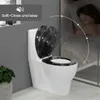 A toilet with a decorative lid is shown next to a sleeping person, illustrating the soft-close feature. Produktbild-Vorschau