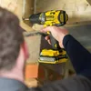 A person is using a yellow and black Stanley Fatmax cordless drill to screw into wooden beams. Produktbild-Vorschau