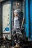 A man in work clothes stands in front of a train car. Produktbild-Vorschau