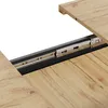 A close-up view of an extendable table mechanism, showing the sliding rails and wooden tabletop. Náhled obrázku produktu
