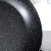 A close-up view of the speckled interior of a black frying pan. Produktbild-Vorschau