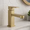 A gold-colored faucet is shown on a white countertop with a tiled backsplash. Náhľad obrázku produktu