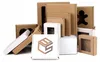 A collection of various cardboard boxes, some with transparent windows, arranged in a studio setting against a white background. Produktbild-Vorschau