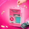 A pink electronic piggy bank with a keypad and coin slot, with a hand inserting a coin. Náhľad obrázku produktu