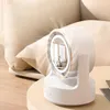 A white desk fan with a built-in mirror and light is placed on a side table next to a couch. Produktbild-Vorschau