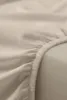 A close-up view of a beige fitted sheet, showing the elasticated edge. Podgląd zdjęcia produktu