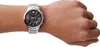 A person's wrist wearing a silver Emporio Armani watch with a black face. Náhled obrázku produktu